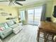Cozy living room with sofa, ceiling fan, dining table and access to a beachfront balcony at 116 S Waccamaw Dr. # 205, Murrells Inlet, SC 29576