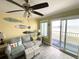 Comfortable living room with ceiling fan, sofa, and a sunny view of the beach and pier at 116 S Waccamaw Dr. # 205, Murrells Inlet, SC 29576