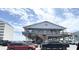 Pier building at Garden City with parking area and cars in front of the building at 116 S Waccamaw Dr. # 205, Murrells Inlet, SC 29576