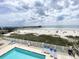 Scenic view of a blue swimming pool, beach and pier under a cloudy sky at 116 S Waccamaw Dr. # 205, Murrells Inlet, SC 29576