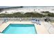 Elevated shot of a clear swimming pool with lounge chairs, a beach, and pier at 116 S Waccamaw Dr. # 205, Murrells Inlet, SC 29576