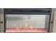 Contemporary fireplace with a black frame, glass front, and red decorative stones at 1311 S Ocean Blvd. # B-1, North Myrtle Beach, SC 29582