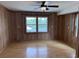 Cozy bedroom featuring wood-paneled walls, hardwood floors, and serene views from the window at 134 Mohican Dr., Georgetown, SC 29440