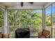 Covered porch featuring a grill, wooden furniture, and a view of the surrounding greenery at 1379 Cottage Dr., Myrtle Beach, SC 29577