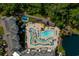Aerial view of complex showing pools, recreation areas, nearby lake, and lush landscaping at 14290 Ocean Hwy. # 312, Pawleys Island, SC 29585