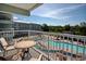 Balcony view showcasing outdoor seating overlooking the community pool and well-manicured landscaping at 14290 Ocean Hwy. # 312, Pawleys Island, SC 29585