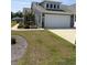 Charming gray home featuring a two-car garage, well-maintained lawn, and landscaped garden beds at 1565 Jardine Loop, Little River, SC 29566