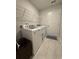 Bright laundry room with tile flooring, white washer and dryer and wire shelving at 1565 Jardine Loop, Little River, SC 29566