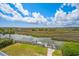 Waterfront backyard view featuring a dock, lush greenery, and beautiful marsh scenery under a partly cloudy sky at 172 Colony Point Dr., Georgetown, SC 29440