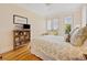 Cozy bedroom with wood floors, a shuttered window, and a bookshelf with framed photos, creating a personalized space at 172 Colony Point Dr., Georgetown, SC 29440