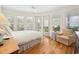 Bright bedroom featuring wood floors, shuttered windows, and a cozy seating area with views at 172 Colony Point Dr., Georgetown, SC 29440