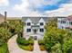 Beautiful two-story home featuring a metal roof, welcoming front porch, lush landscaping, and a driveway at 172 Colony Point Dr., Georgetown, SC 29440