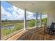Expansive covered porch features white columns, wood floors, seating, and a scenic view of the marsh and sky at 172 Colony Point Dr., Georgetown, SC 29440