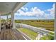 Relaxing covered porch with marsh views, white columns, rocking chairs and cushioned seating for outdoor relaxation at 172 Colony Point Dr., Georgetown, SC 29440