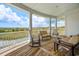 Inviting covered porch with marsh views, white columns, rocking chairs and cushioned seating for outdoor relaxation at 172 Colony Point Dr., Georgetown, SC 29440