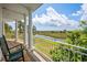 Scenic covered porch with marsh views, white columns, rocking chairs, and lush green scenery under a partly cloudy sky at 172 Colony Point Dr., Georgetown, SC 29440