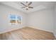 Light-filled bedroom showcasing wood floors, tray ceilings and a large window with neighborhood views at 178 Six Mile Creek Dr., Georgetown, SC 29440