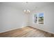 Bright dining area featuring hardwood floors, chandelier, and a large window overlooking the yard at 178 Six Mile Creek Dr., Georgetown, SC 29440