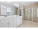 Bathroom with double vanity, large framed mirror, and a glass-enclosed tiled shower at 18 Coastal Breeze Trail, Pawleys Island, SC 29585