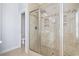 Bathroom with a tiled shower featuring glass doors and a rain shower head, alongside a water closet at 18 Coastal Breeze Trail, Pawleys Island, SC 29585