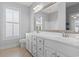 Inviting bathroom features a dual sink vanity, framed mirror, and plantation shutters at 18 Coastal Breeze Trail, Pawleys Island, SC 29585