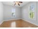 Bright bedroom features wood floors, gray walls, ceiling fan, and sun-filled windows with plantation shutters at 18 Coastal Breeze Trail, Pawleys Island, SC 29585