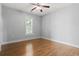 Minimalist bedroom featuring hardwood floors, a window with shutters, and neutral paint for a calming atmosphere at 18 Coastal Breeze Trail, Pawleys Island, SC 29585
