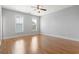 Bright bedroom features wood floors, gray walls, ceiling fan, and sun-filled windows with plantation shutters at 18 Coastal Breeze Trail, Pawleys Island, SC 29585