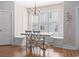 Charming dining area featuring a built-in bench, a chandelier, and ample natural light from shuttered windows at 18 Coastal Breeze Trail, Pawleys Island, SC 29585