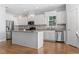 Open kitchen with white cabinets, granite countertops, stainless steel appliances, and hardwood flooring at 18 Coastal Breeze Trail, Pawleys Island, SC 29585