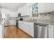 Bright kitchen featuring white cabinets, granite counters, stainless steel appliances, and tile backsplash at 18 Coastal Breeze Trail, Pawleys Island, SC 29585