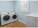 Functional laundry room with a modern washer and dryer, a countertop, storage cabinets, and natural light at 18 Coastal Breeze Trail, Pawleys Island, SC 29585