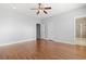A spacious main bedroom with a ceiling fan, hardwood floors, and a view of the en-suite bathroom at 18 Coastal Breeze Trail, Pawleys Island, SC 29585
