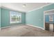 An empty bedroom featuring large windows, plush carpeting and blue painted walls at 1808 Zodiac Court, Myrtle Beach, SC 29577