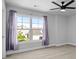 Sun-filled bedroom with plush carpeting, a ceiling fan, and large window views of the neighborhood at 1808 Zodiac Court, Myrtle Beach, SC 29577