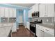 Modern kitchen with white cabinets, stainless steel appliances, and gray backsplash at 1808 Zodiac Court, Myrtle Beach, SC 29577