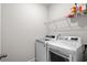 Modern laundry room featuring front-load washer and dryer with overhead shelving at 1808 Zodiac Court, Myrtle Beach, SC 29577