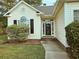 Inviting front entrance with a glass storm door, decorative window, and mature bushes at 185 Lander Dr., Conway, SC 29526
