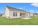 Exterior rear view of home featuring a covered patio and a spacious grassy yard with white siding at 192 Six Mile Creek Dr., Georgetown, SC 29440