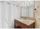 Well-lit bathroom vanity features granite countertop and shower with curtain at 2000 Ocean Blvd. N # Ph11, Myrtle Beach, SC 29577