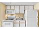 Efficient kitchen with white appliances and cabinetry, offering essential amenities for meal preparation and storage at 2000 Ocean Blvd. N # Ph11, Myrtle Beach, SC 29577