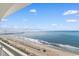 Balcony view of white sandy beach, blue ocean, and pier in the distance at 2000 Ocean Blvd. N # Ph12, Myrtle Beach, SC 29577