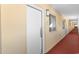 Hallway with white doors, beige walls, red-carpeted floors and windows with natural light at 2000 Ocean Blvd. N # Ph12, Myrtle Beach, SC 29577