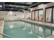 Inviting indoor pool area with clear blue water, lounge chairs, and doors leading to an outdoor patio area at 201 74Th Ave. N # 2638, Myrtle Beach, SC 29572