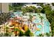 Aerial view of a waterpark with slides, a lazy river, and lush tropical landscaping for Gathering fun and relaxation at 201 74Th Ave. N # 2638, Myrtle Beach, SC 29572