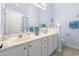 Bright bathroom with double sinks, a large mirror, and blue wall paint at 205 Carriage Lake Dr., Little River, SC 29566