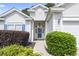 Inviting front entrance with lush landscaping and a charming door with decorative wreath at 205 Carriage Lake Dr., Little River, SC 29566