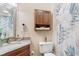 Well-lit bathroom features granite countertop, wood cabinets, and shower with patterned curtain at 215 77Th Ave. N # 702, Myrtle Beach, SC 29572