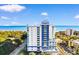 Exterior of white and blue condo building with many windows offering beautiful beach and ocean views at 215 77Th Ave. N # 702, Myrtle Beach, SC 29572