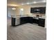 Modern kitchen boasts stainless steel appliances, granite countertops, and dark cabinetry at 2247 Union Church Rd., Little River, SC 29566